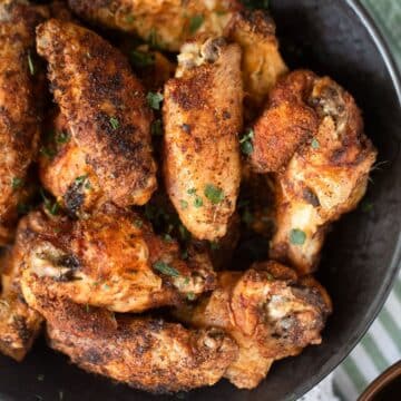 many extra crispy cornstarch chicken wings in a black bowl.