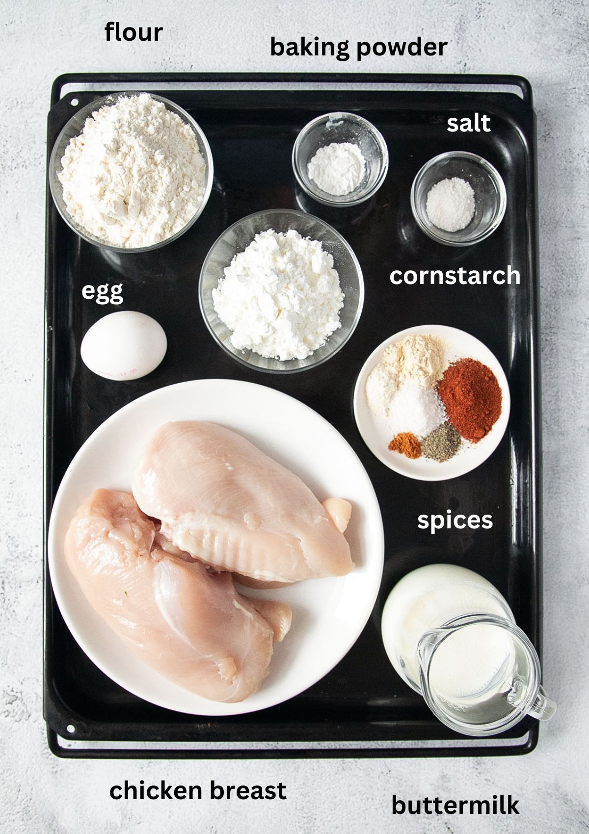 listed ingredients in bowls for making fried chicken breasts.