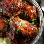 close up of glossy chicken thighs with honey and soy sauce on a plate.