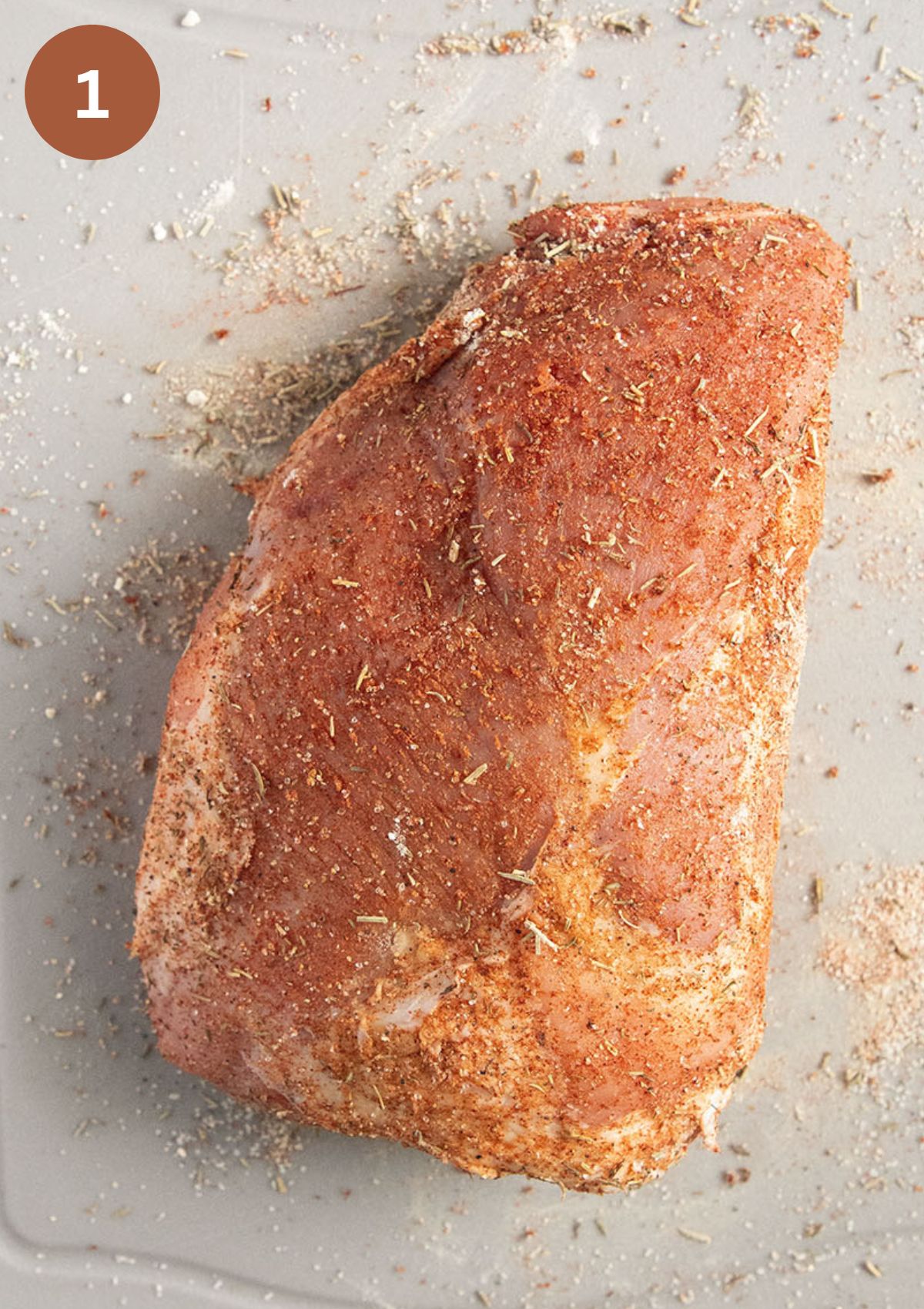 raw piece of pork shoulder seasoned with a spice blend.