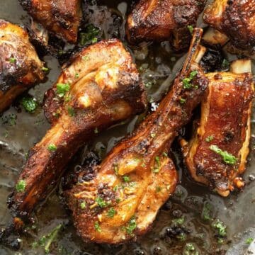 several lamb ribs cooked in the oven and sprinkled with parsley.