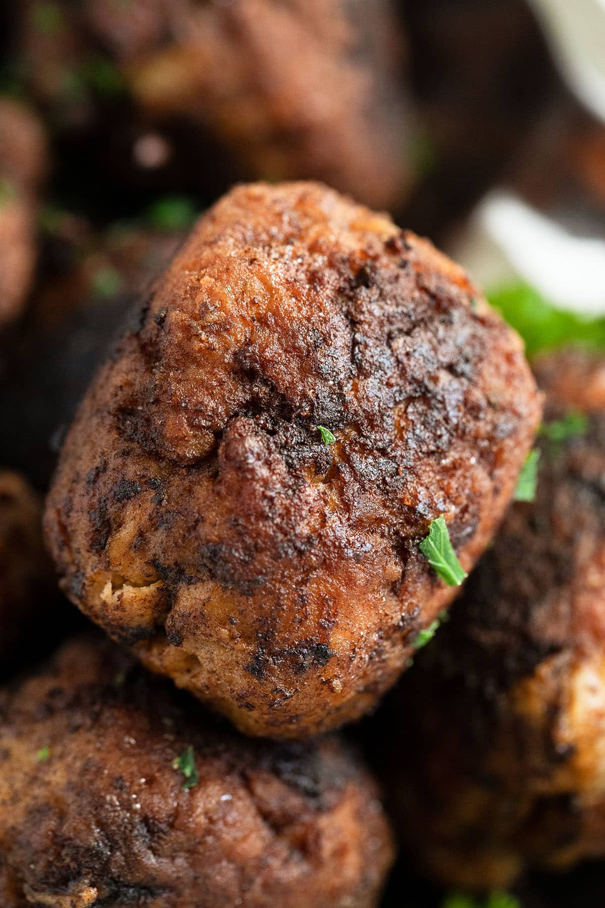 close up of one round brown meatball.