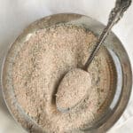 homemade spice blend for pork on a small plate with a spoon.