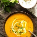 pinterest image of a bowl of carrot and lentil soup served with yogurt.