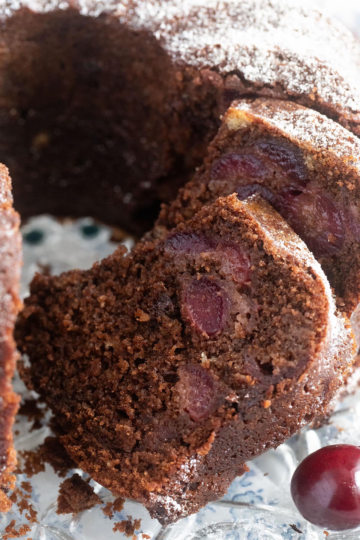 close up slices of chocolate bundt cake filled with cherries.