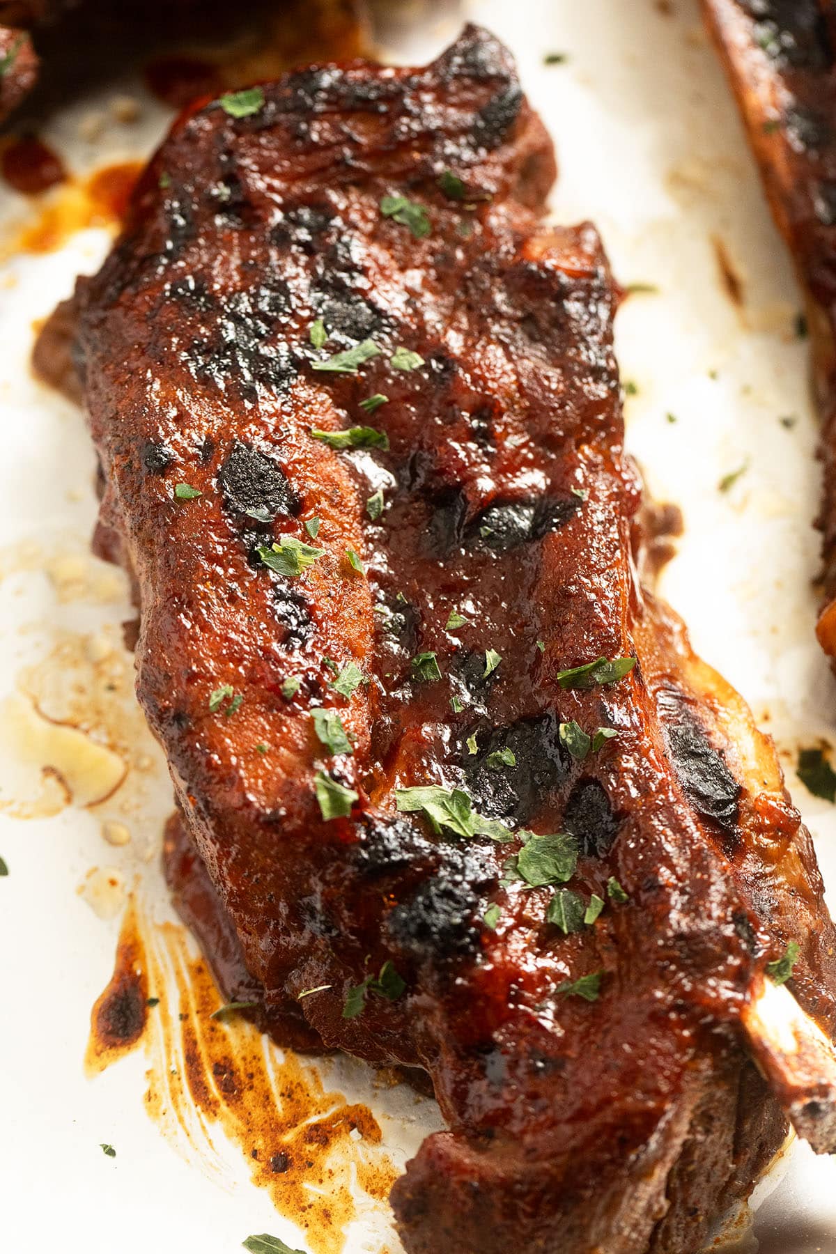 one large pork rib glazed with barbecue sauce. 