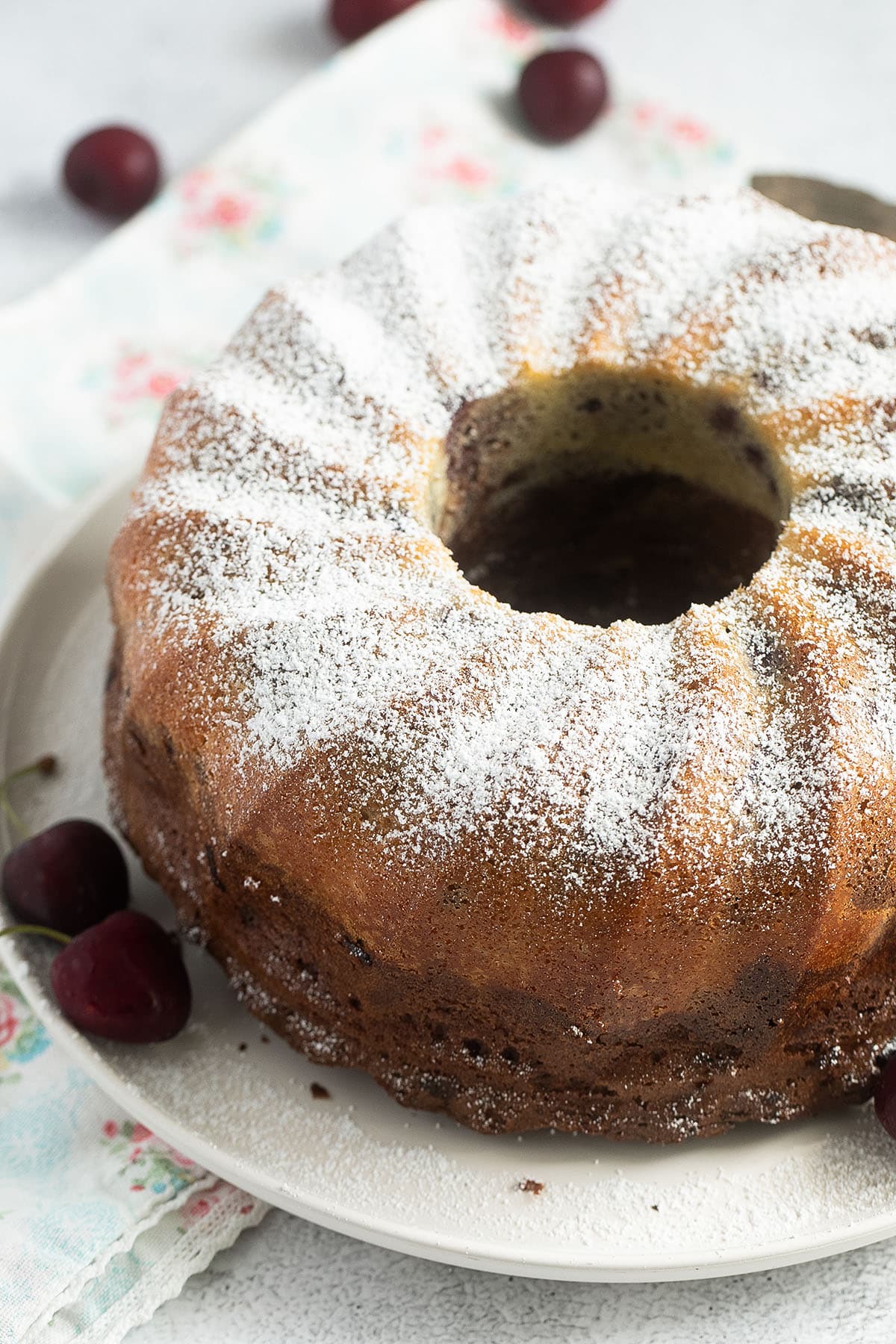 close up of a marbled cherry bundt cake on a white plate.