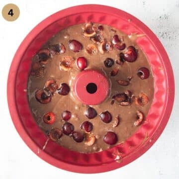 chocolate cake batter covered with cherries in a silicon bundt cake form.