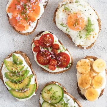 six cottage cheese toasts with salmon, egg, tomatoes, avocado, banana and cucumber.