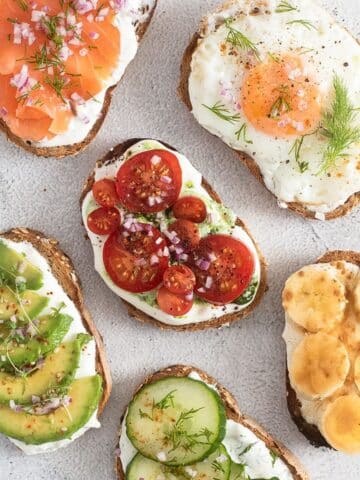 six cottage cheese toasts with salmon, egg, tomatoes, avocado, banana and cucumber.