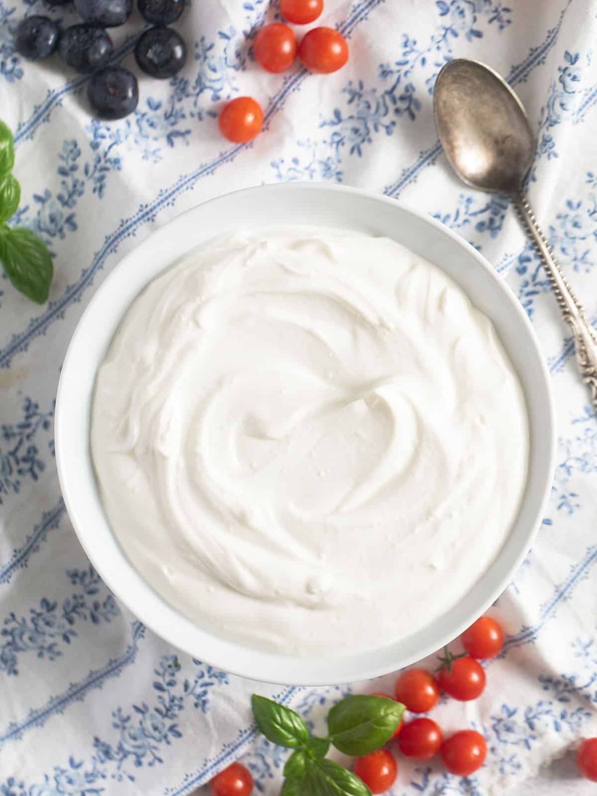 blended cottage cheese in a bowl, tomatoes and blueberries around it.