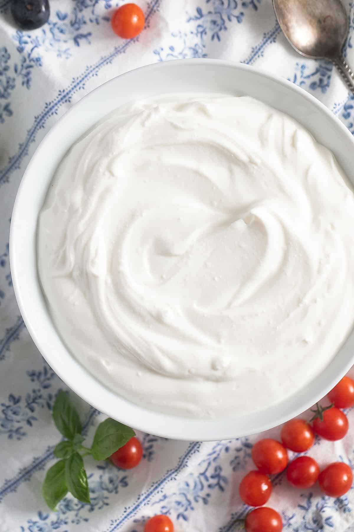 creamy blended cottage cheese with many tiny tomatoes around it.