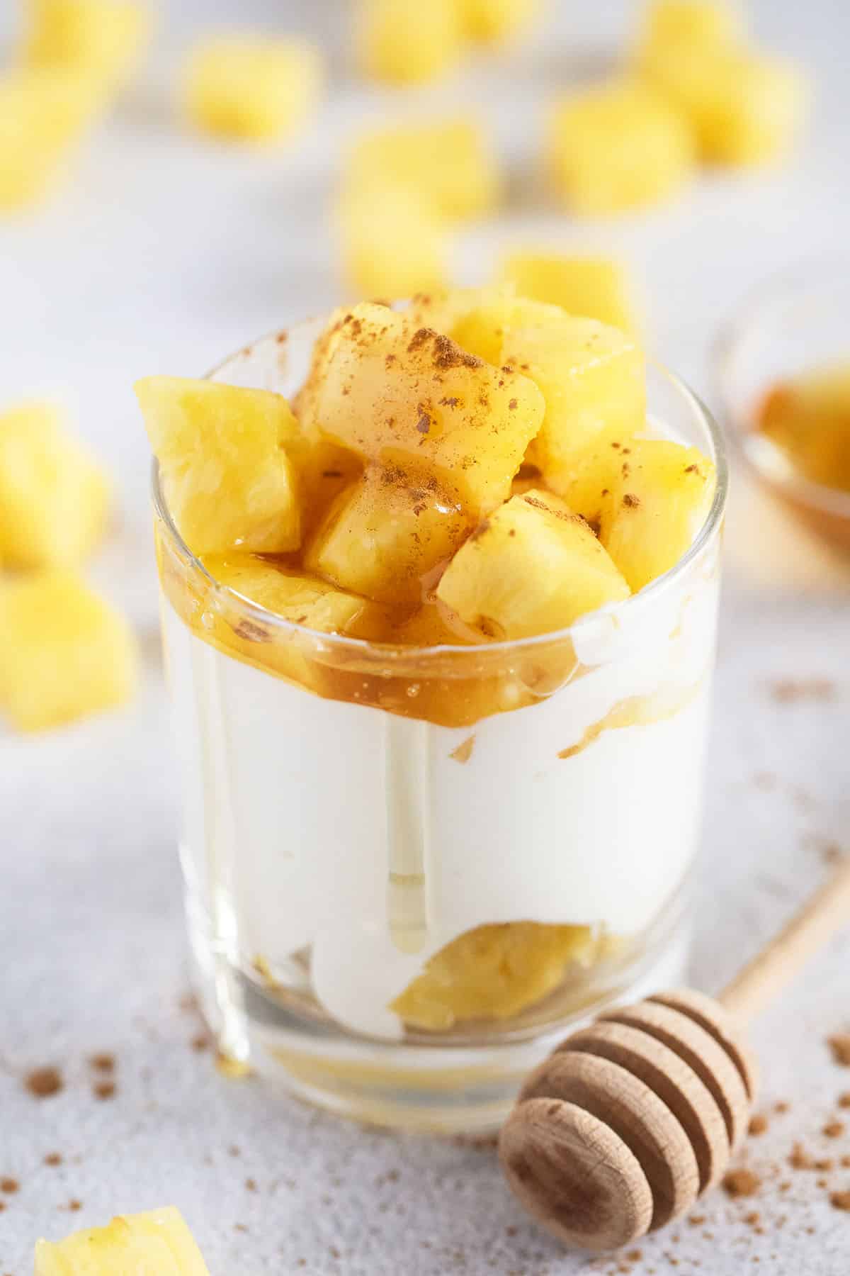 jar full of whipped cottage cheese topped with pineapple chunks; more pineapple in the background.