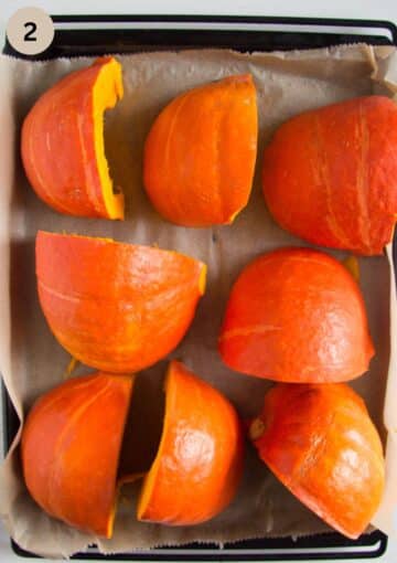 large pumpkin quarters on a baking sheet before baking.