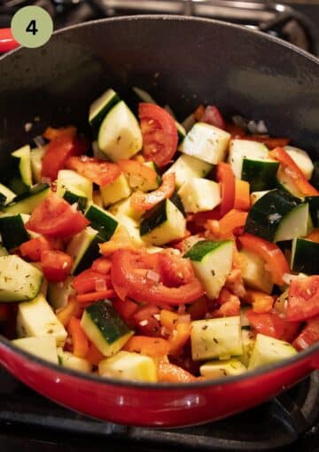 sauteing zucchini, tomatoes and peppers in a pot.