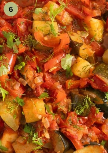 close up of chunky vegetable stew sprinkled with fresh herbs.