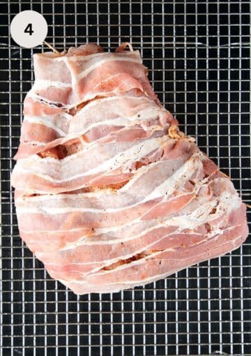 raw turkey breast wrapped with bacon slices on a wire rack.