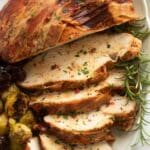 bacon-wrapped turkey breast slices with a rosemary sprig and sprouts.