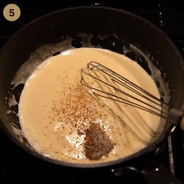 adding spices to white sauce in a saucepan.