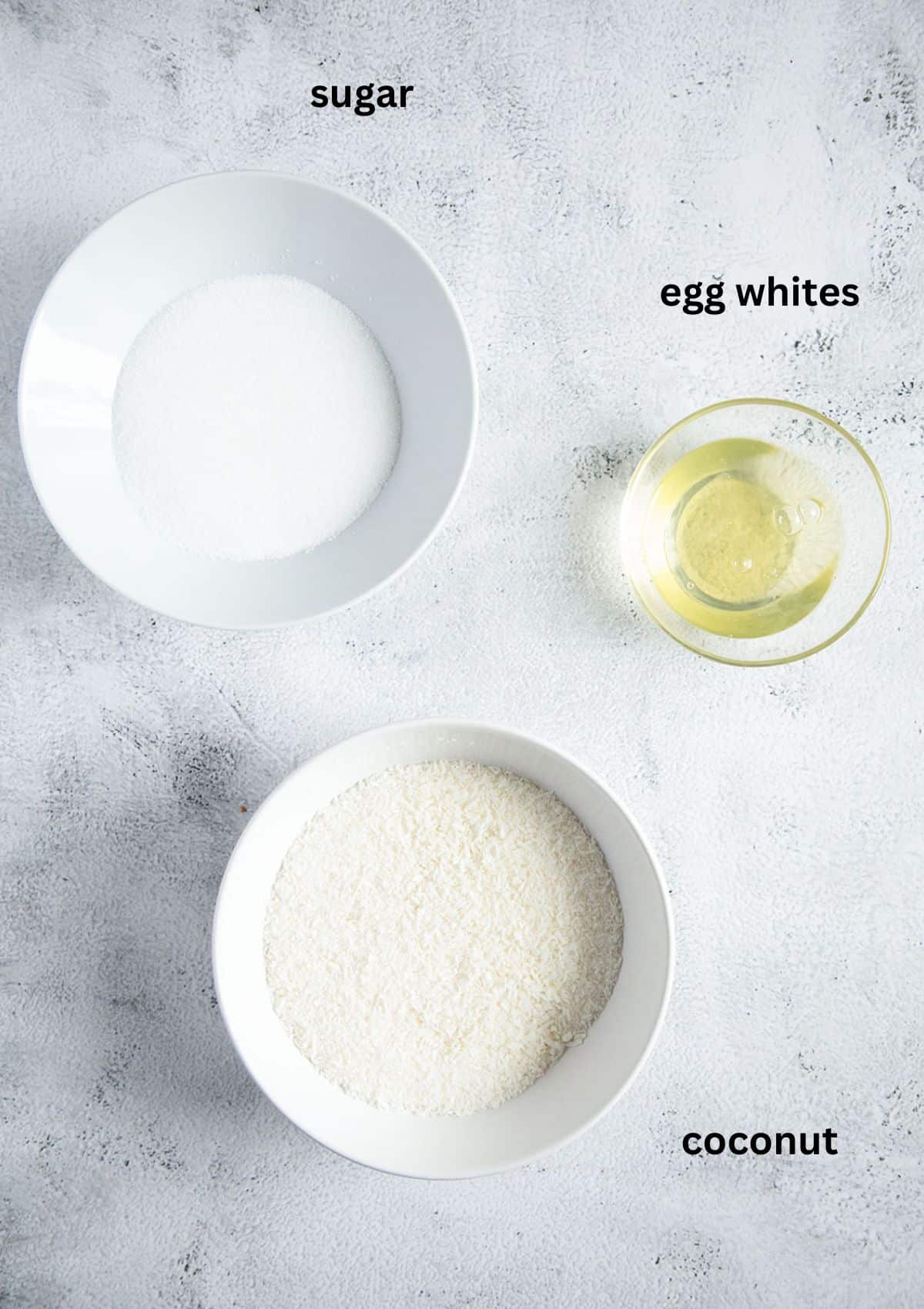 bowls with egg whites, sugar and desiccated coconut for macaroons.