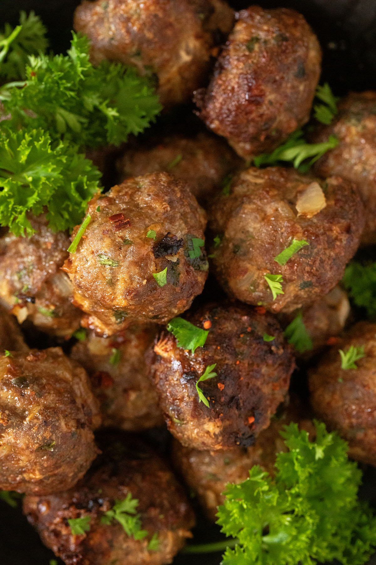 close up of no breadcrumbs meatballs and fresh parsley.