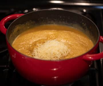 adding parmesan to creamy soup.