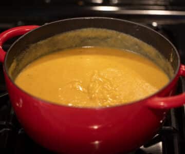 blended orange colored soup in a dutch oven.