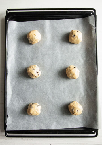 raw cookie balls on a baking sheet.