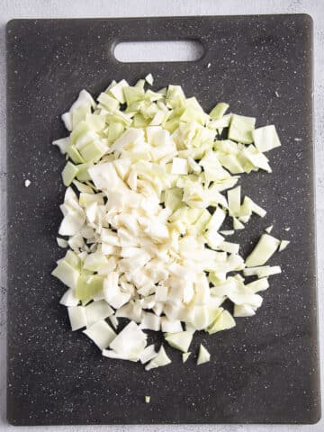 chopped cabbage on a gray cutting board.