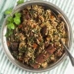 lamb and rice on a silver plate with a fork sticking into it.
