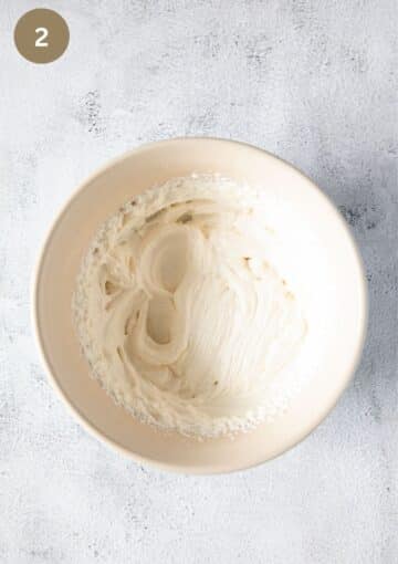 whipped ricotta in a bowl with mixer marks in it.