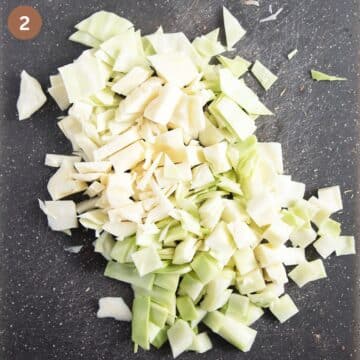 roughly chopped cabbage on a cutting board.