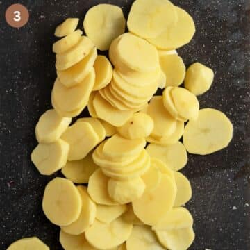 thinly sliced potato rounds on a cutting board.