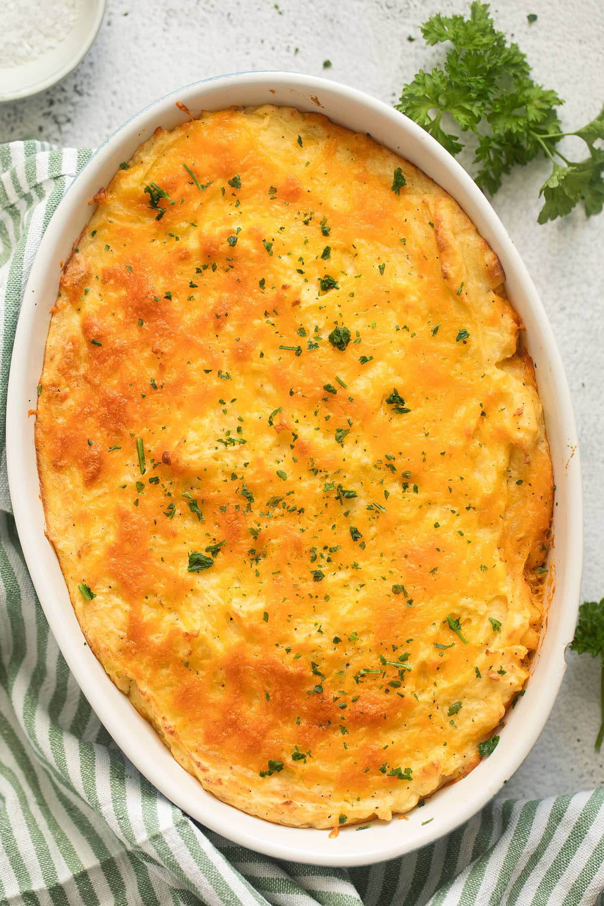 casserole dish containg golden baked shepherd's pie sprinkle with parsley.