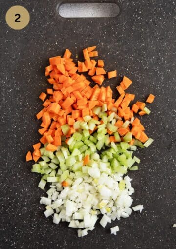 diced carrots, celery and onions on a cutting board.