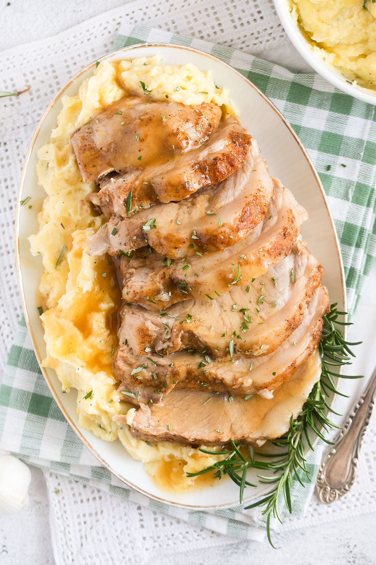one large platter with sliced pork loin, mashed potatoes and gravy.