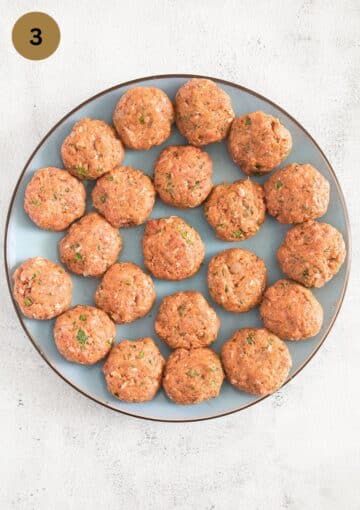 shaped, uncooked meatballs on a large plate.
