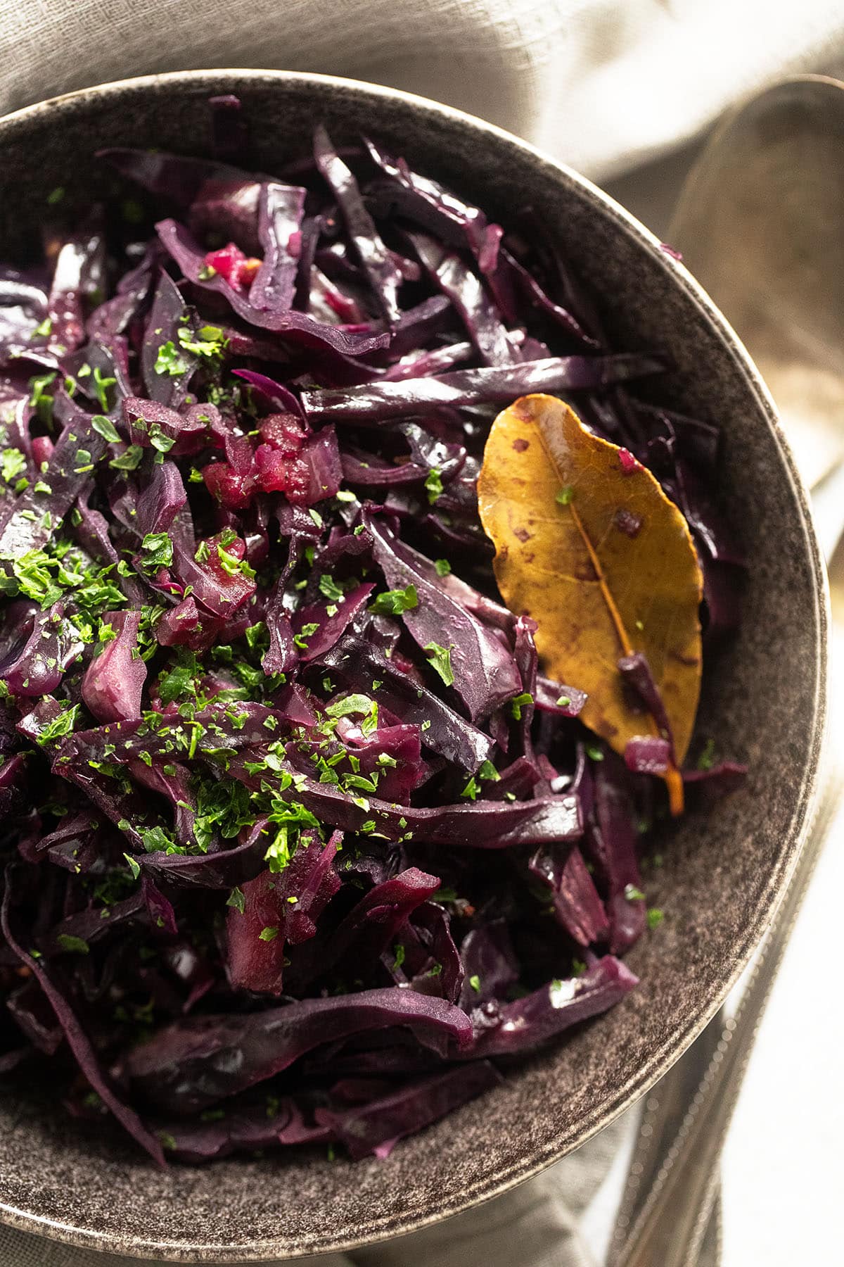 bowl with stewed red cabbage, a bay leaf and parsley.