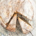 apple olive oil cake sliced on a cake platter.