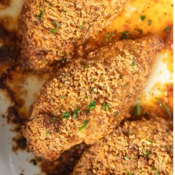 almond crusted chicken breast pieces golden brown and sprinkled with parsley.