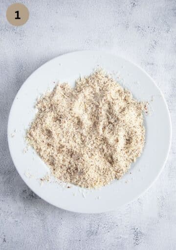 parmesan and ground almonds mixed on a large shallow plate.