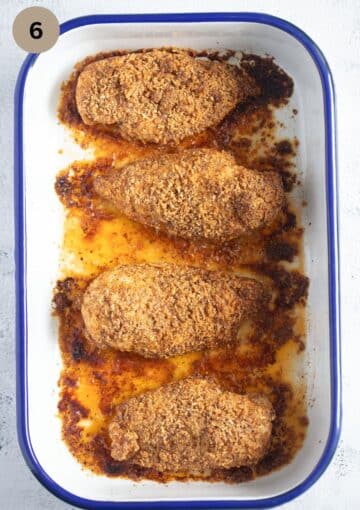 four crusted chicken breast pieces in a baking tin.