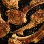 greek lamb chpps sprinkled with fresh herbs.