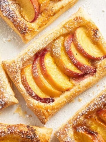 peach puff pastry with sliced fruit pieces and honey drizzle.