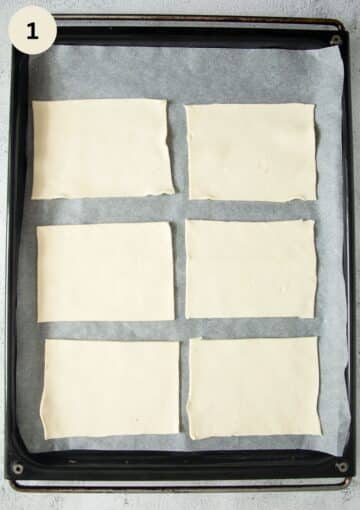 six rectangles of unbaked puff pastry dough on a baking sheet lined with parchment paper.