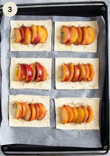 topping puff pastry pieces with sliced peaches.