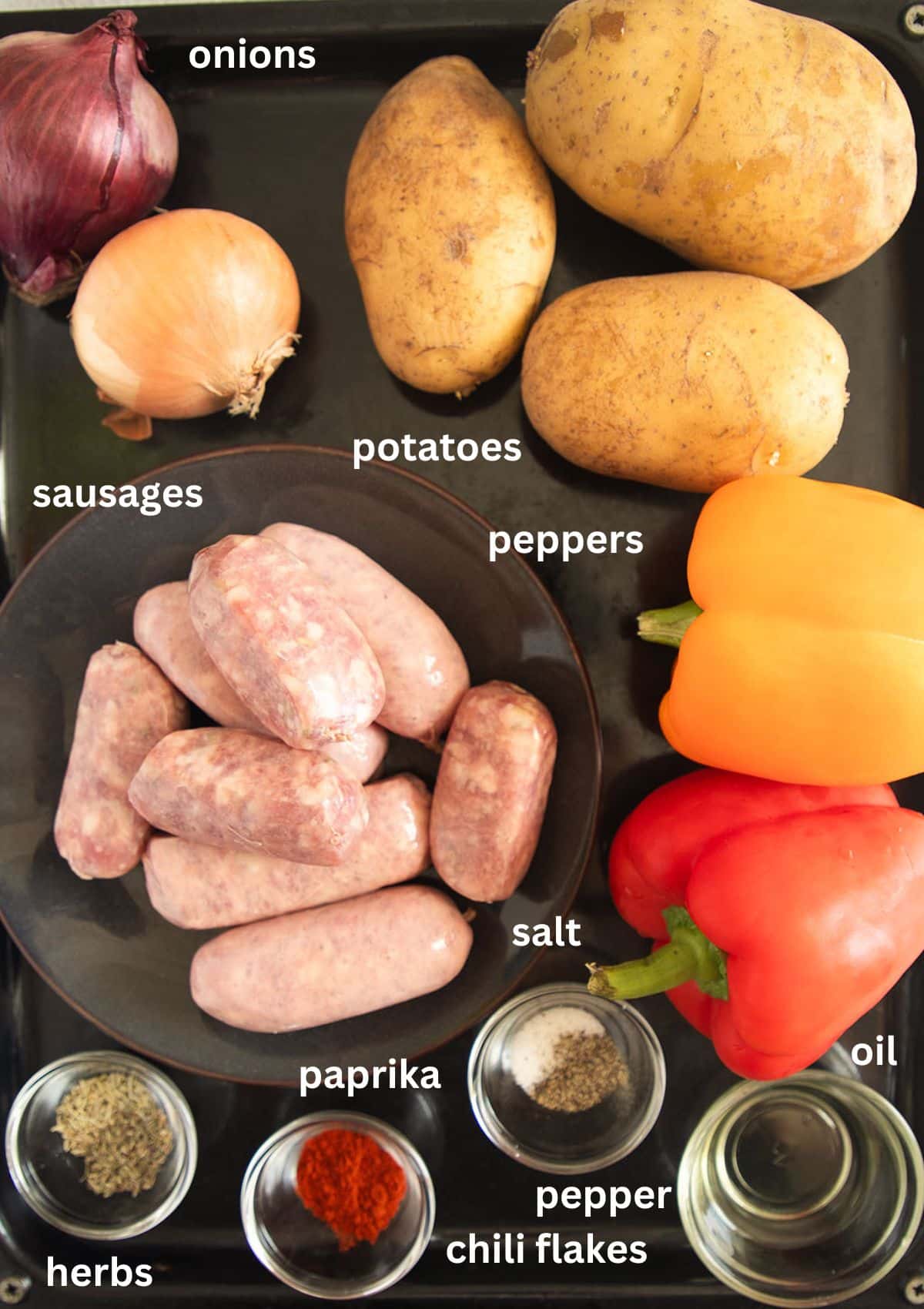 listed ingredients for roasting italian sausages with potatoes, peppers, onions and spices.