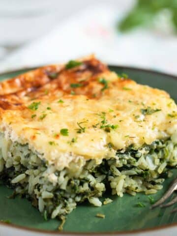 a piece of spinach rice casserole on a green plate.