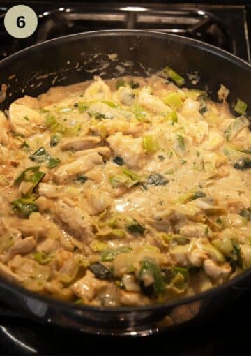 leeks and chicken pieces cooking in a white heavy cream sauce.