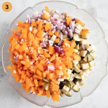 chopped eggplants, peppers, onions, carrots, and garlic in a large bowl.